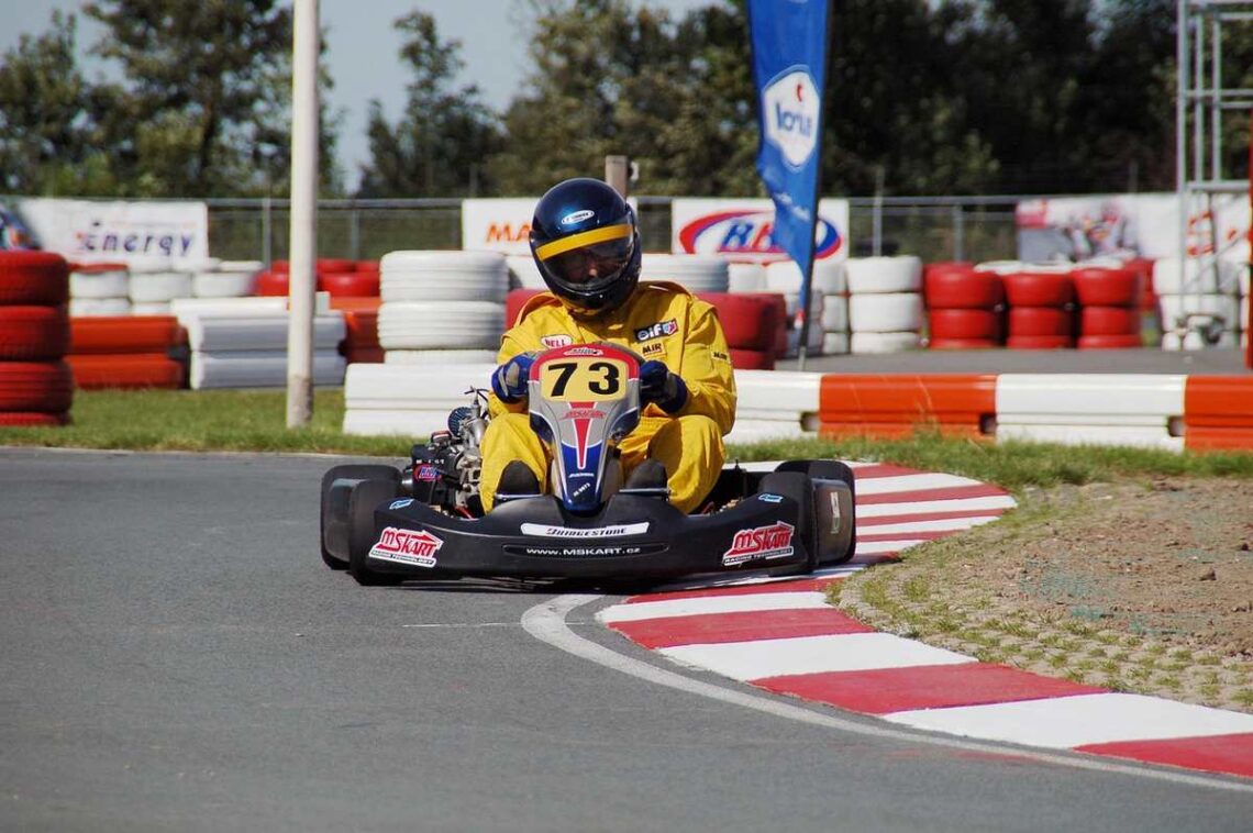 Un coureur en kart noir number 73 tourne sur virage